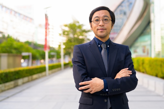 Portrait of Japanese businessman getting fresh air with nature in the city outdoors