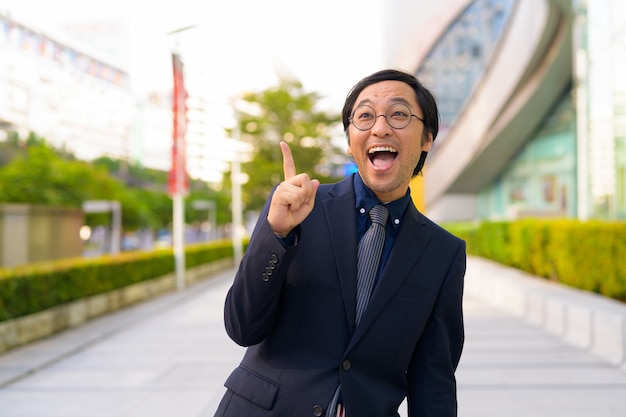 Portrait of Japanese businessman getting fresh air with nature in the city outdoors