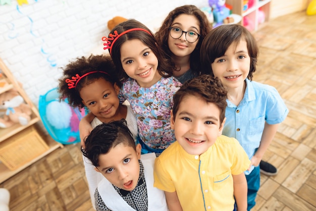 Portrait of joyful children in holiday hats at birthday party