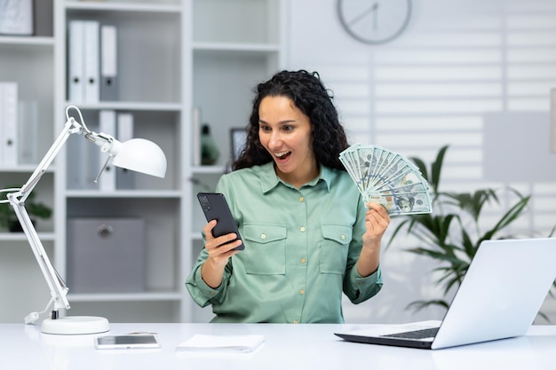 Portrait of joyful happy and successful business woman inside office hispanic woman smiling holding