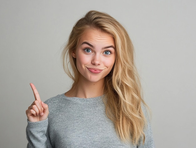 Portrait of a joyful young blonde girl pointing