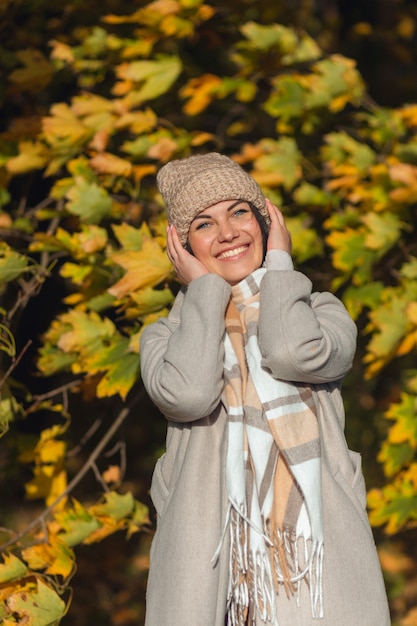 Portrait of a joyful young woman enjoying in the autumn park.