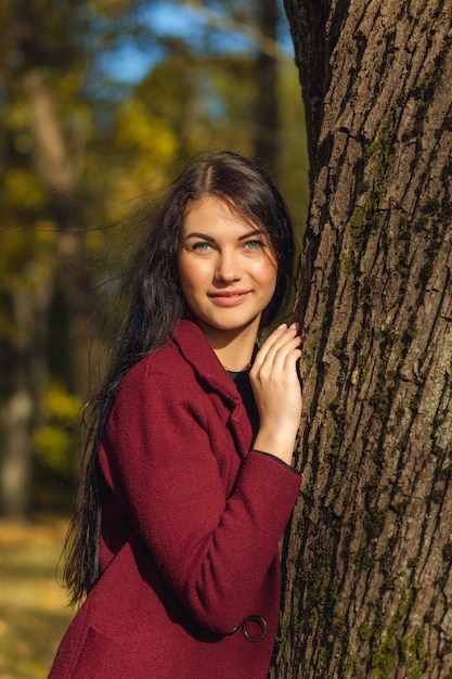 Portrait of a joyful young woman enjoying in the autumn park.