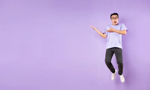 Portrait of a jumping asian man, isolated on purple background