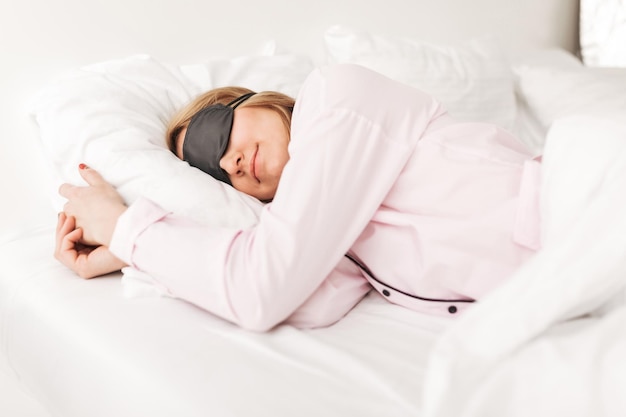 Portrait of lady wearing black eyes mask while sleeping in bed at home