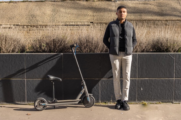 Portrait of a latin business man with an electric scooter