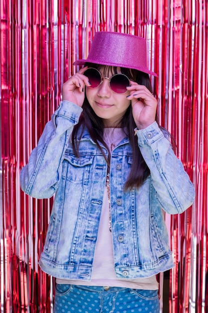 Portrait of a latin teen girl wearing a hat and holding some sunglasses