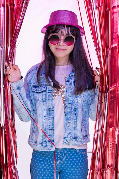 Portrait latin teen girl wearing a hat and sunglasses at a party