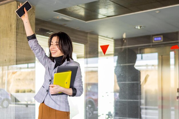 Portrait of a Latina businesswoman celebrating a success outside her office