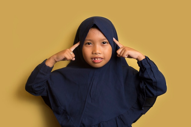 Portrait of a little asian muslim hijab girl  thinks