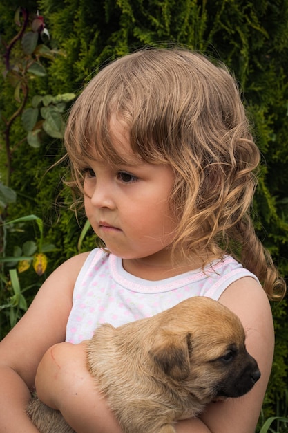 Portrait of a little beautiful curlyhaired girl with a puppy