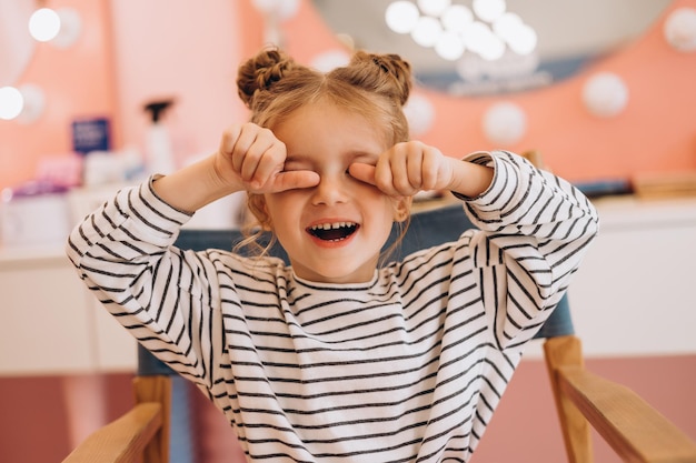 Portrait of a little beautiful girl with a stylish hairstyle in a beauty salon