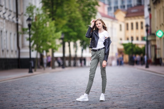 Portrait of little beautiful stylish kid girl in city urban street