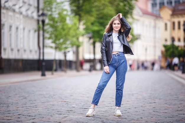 Portrait of little beautiful stylish kid girl in city urban street