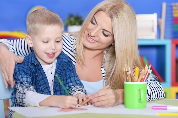 Portrait of a little boy drawing with his mother