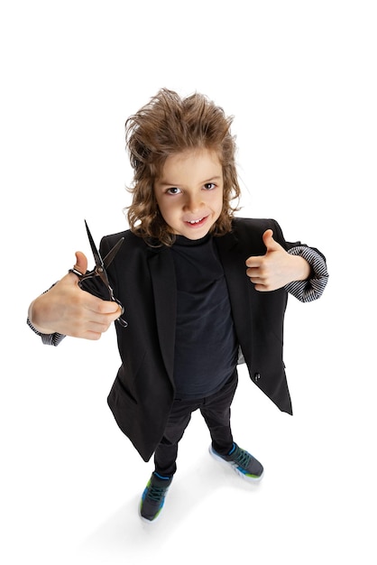 Portrait of little boy in image of stylish haordresser barber isolated over white studio background