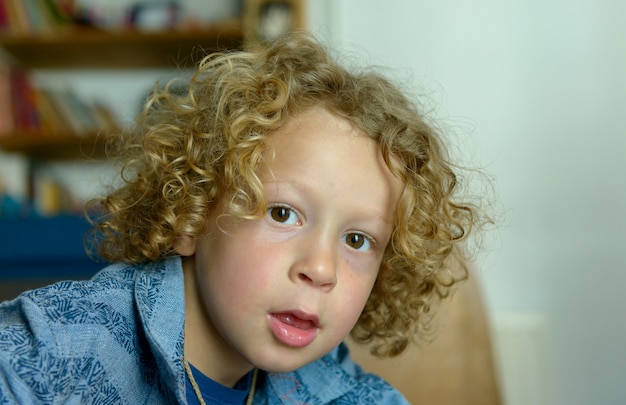 Portrait of  little boy with blond and curly hair