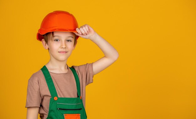 Photo portrait little builder in hardhats child building helmet hard hat little builder in helmet child dressed as a workman builder little boy wearing helmet builder