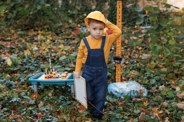 Portrait little builder in hardhats child dressed as a workman builder caucasian industry worker