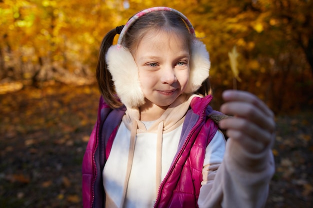 Portrait of a little girl in an autumn park on a sunny day