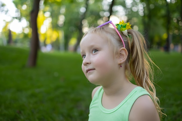 Portrait of a little girl model who poses for the camera while in the park