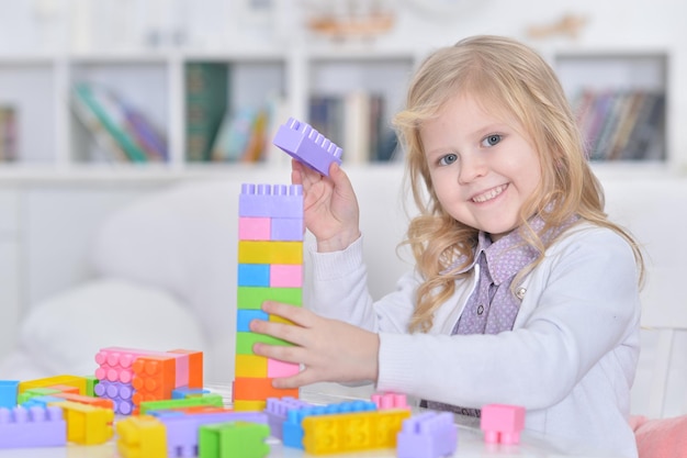 Portrait of little girl playing with colorful plastic blocks