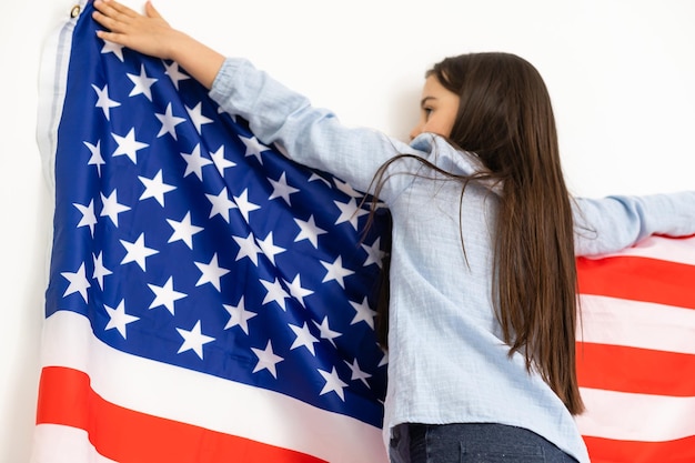 Portrait of a little girl with the flag of America. American education, study in America.