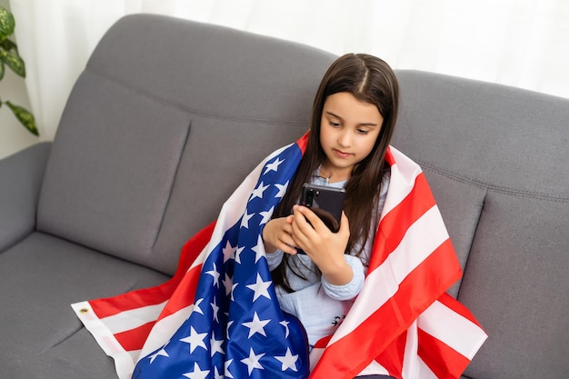 Portrait of a little girl with the flag of America. American education, study in America.