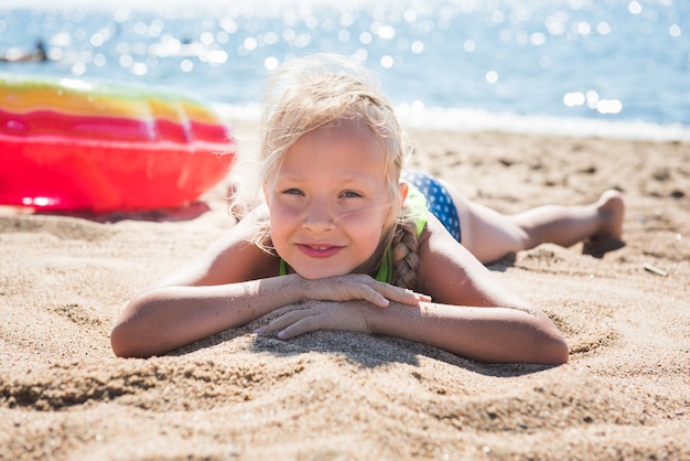 Portrait of little girl with inflatable rubber circle on beach