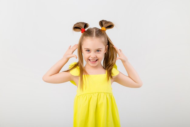 Portrait of a little girl with long hair on a light space