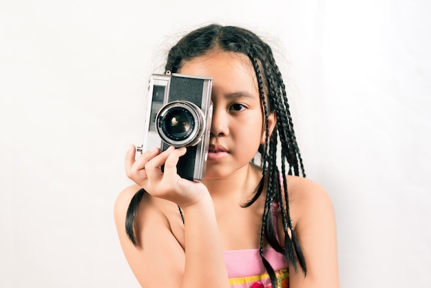 Portrait of the little girl with vintage camera isolated 