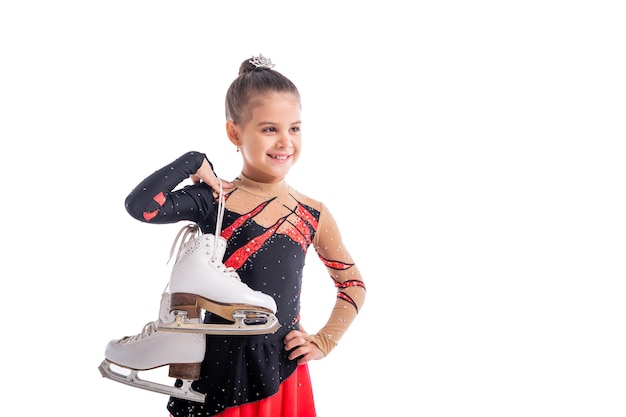 Portrait of a little laughing skater with skates in her hands