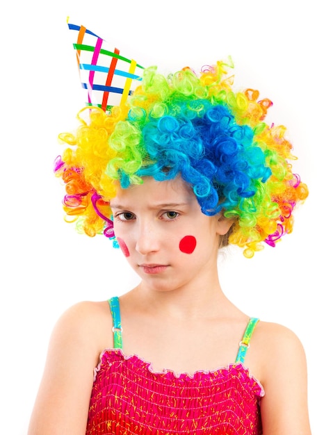 Portrait of little sad girl in clown wig isolated on white backg