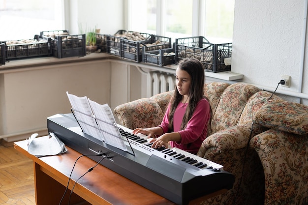 Portrait of little sad girl in ruined building. little settler plays the piano. Refugees.