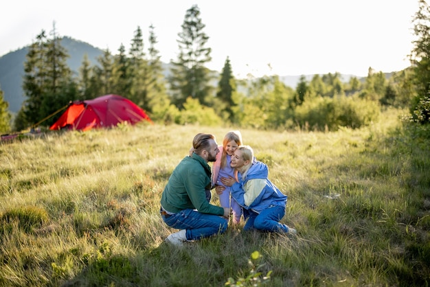 Portrait of a lovely couple with little girl traveling in mountains