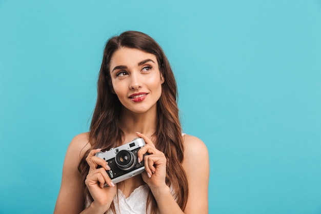 Portrait of a lovely young woman holding photo camera