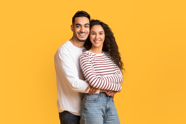 Portrait Of Loving Arab Man And Woman Embracing And Smiling At Camera