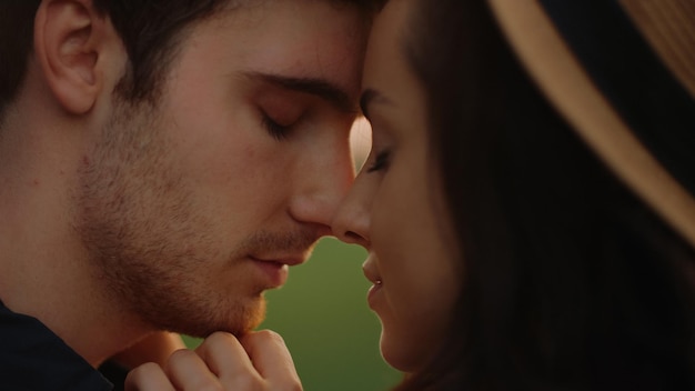 Portrait of loving man and woman touching foreheads outdoors