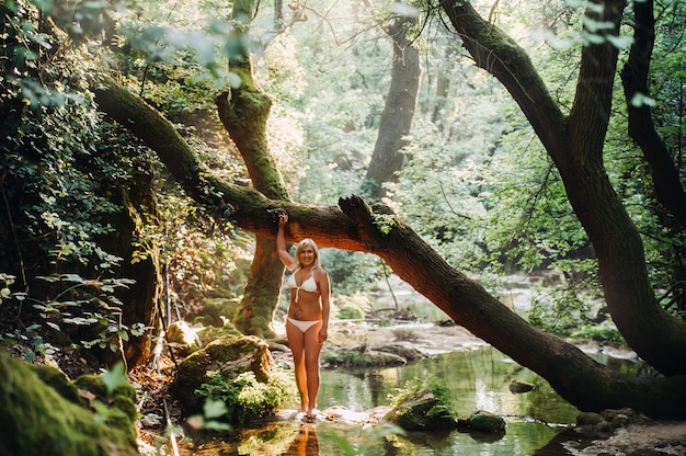 Portrait of a magnificent sexy woman in a bikini among the rainforest. Makeup, cosmetics. Beauty, fashion. Spa, healthcare. Tropical vacation.