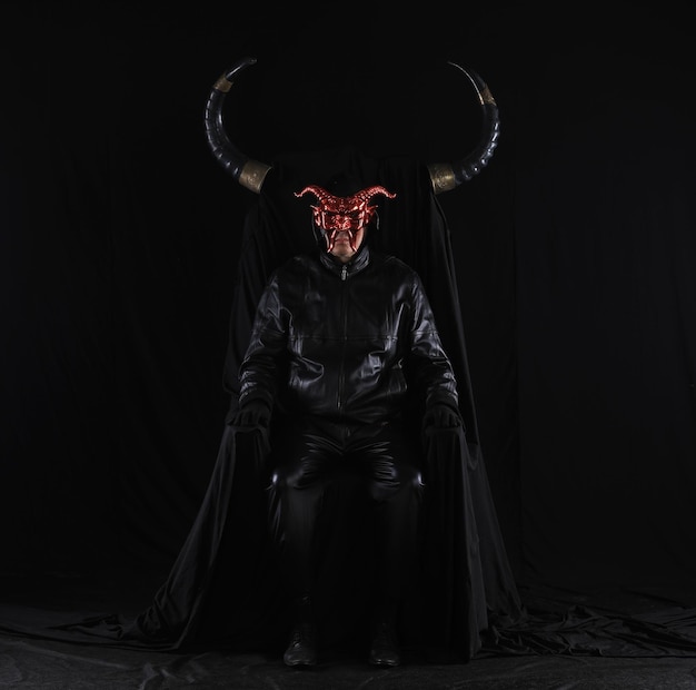 portrait of a male devil with horns on a black throne