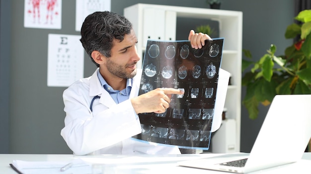 portrait of a male doctor looking at xray picture