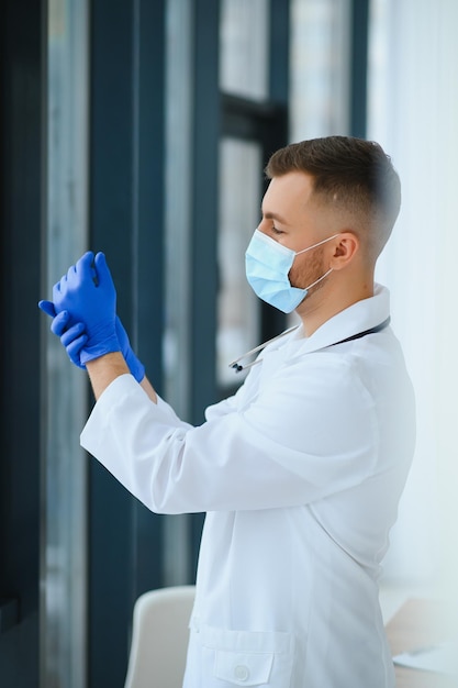 Portrait of male doctor wearing surgical mask is ready to help patients with coronavirus or covid virus