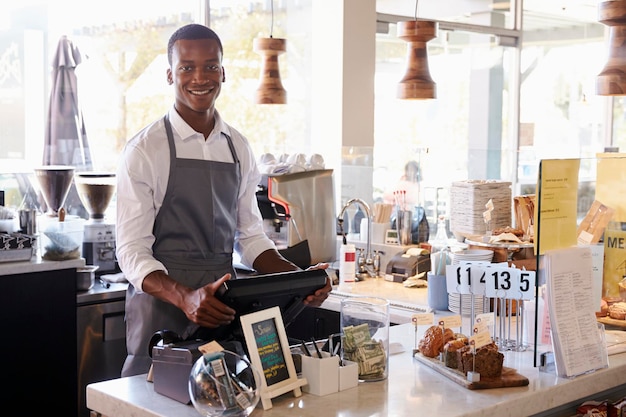 Portrait Of Male Employee Working At Delicatessen Checkout