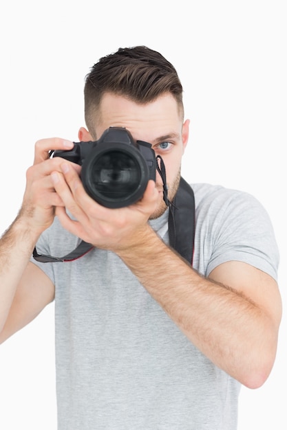 Portrait of male photographer with photographic camera over white background