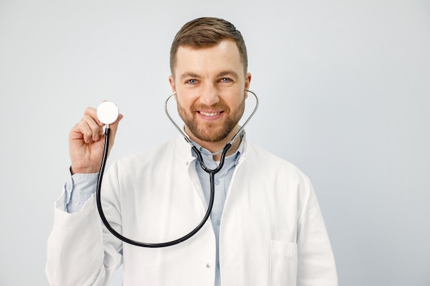 Portrait of a male physician looking at camera holding a stethoscope