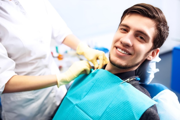 Portrait of male smile face Dental inspection is being given to Beautiful man surrounded by dentist