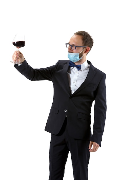 Portrait of male sommelier in suit and protective face mask isolated over white background