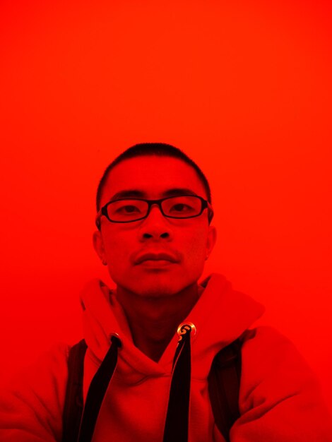 Photo portrait of man against red background