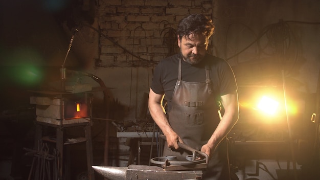 Portrait of a man of a blacksmith in the working atmosphere.