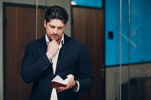 Portrait man businessman in black suit in office.